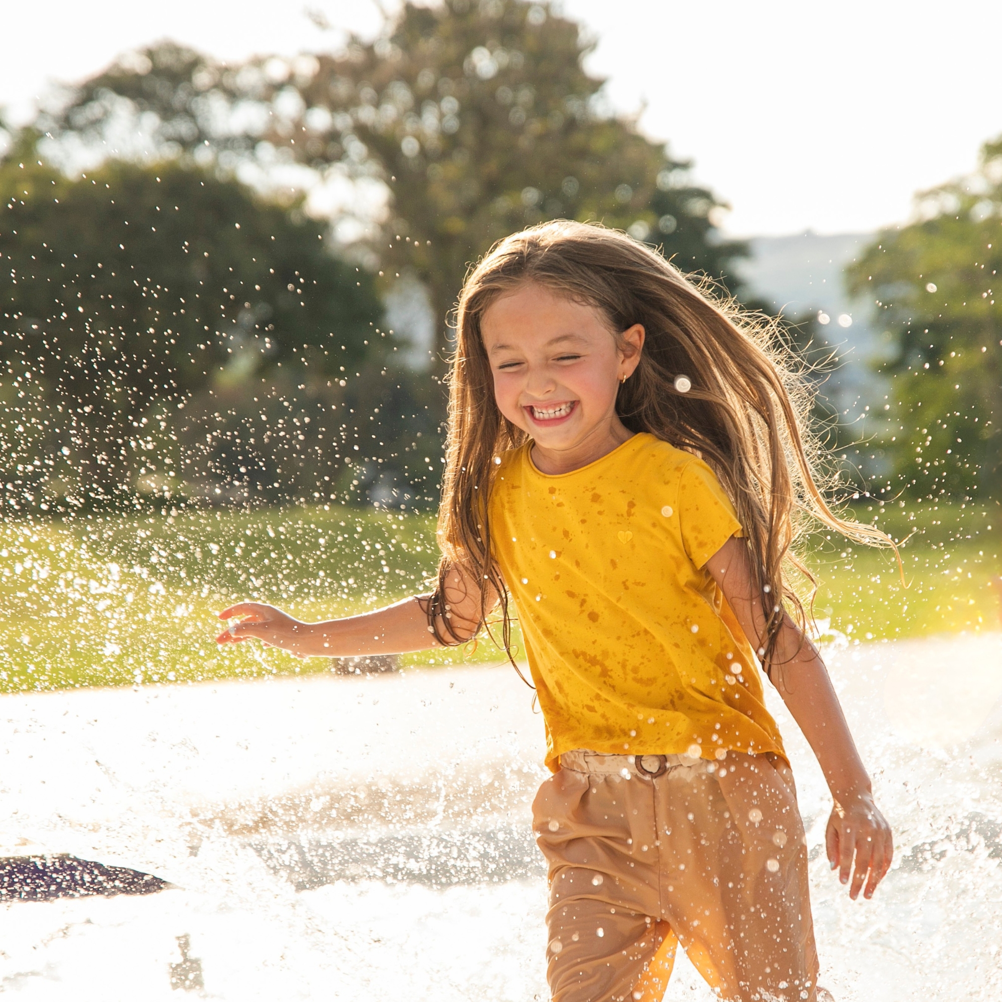 Enfants jouant avec de l'eau dans le jardin en été, éclats de rire